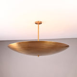 Solid brass disc-style pendant light featuring a wide, shallow bowl design for warm indirect lighting.