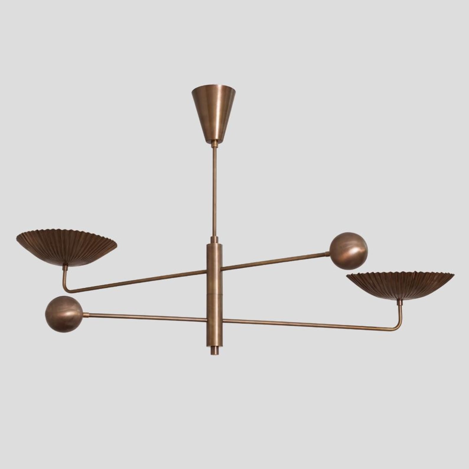 Solid brass chandelier with sculpted fluted bowl shades and minimalist linear arms, industrial-inspired handmade ceiling lamp.