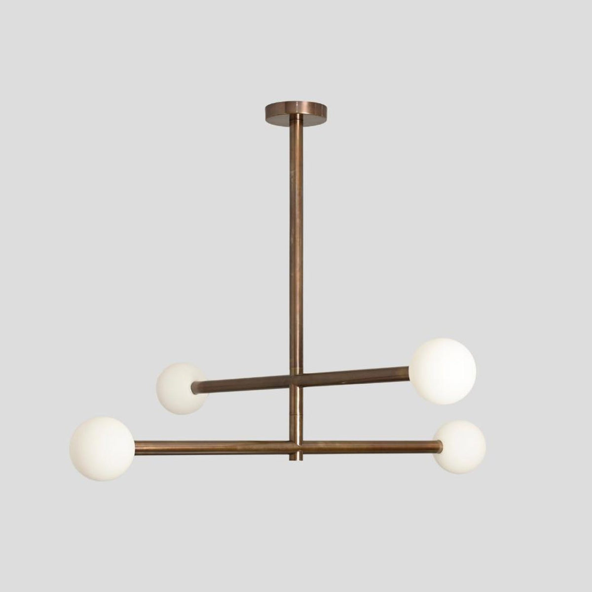 Solid brass modern chandelier featuring four globe lights in a minimalist industrial style.