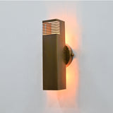 Solid brass up-down wall sconce creating soft warm light above and below the rectangular tube body