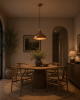 Solid copper dome pendant light hanging above a kitchen island with warm downward glow and artistic copper finish