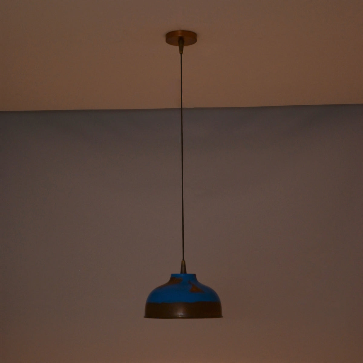 Solid copper dome pendant light hanging above a bedroom with warm ambient lighting and decorative style