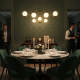 Sorrento brass wall sconce shown illuminated with warm ambient light from three glowing glass globes
