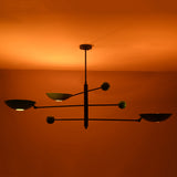 Ambient night view of Sputnik chandelier with colorful disc shades glowing warmly against ceiling