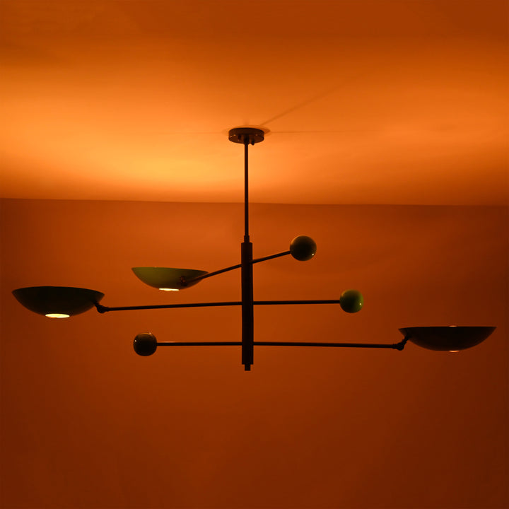 Ambient night view of Sputnik chandelier with colorful disc shades glowing warmly against ceiling