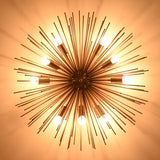 Overhead ceiling view of a glowing sunburst brass chandelier with multiple bulbs