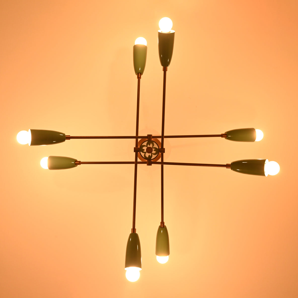 Warm-lit top view of teal and brass Sputnik chandelier showing geometric mid-century layout and eight light arms.