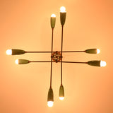 Warm-lit top view of teal and brass Sputnik chandelier showing geometric mid-century layout and eight light arms.