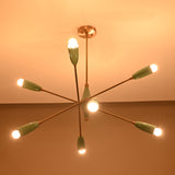 Modern mid-century Sputnik chandelier in teal and brass illuminated warmly, featuring eight angled arms with cone shades.