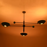 Handmade Sputnik ceiling chandelier with colorful brass disc shades glowing in dark space