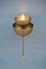 Stacked bowl brass wall sconce illuminated with warm light, handcrafted brass wall decor lighting for interiors