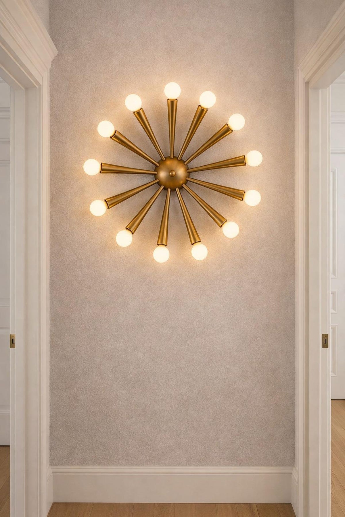 12-light starburst brass wall fixture mounted in a hallway, adding architectural interest with warm, indirect lighting.