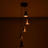 Close perspective of the Sutton Cascade Cone Multi Pendant Chandelier highlighting the warm glow and staggered five-light cascading design.