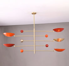 Sculptural modern chandelier with red and brass domes in balanced orbit design