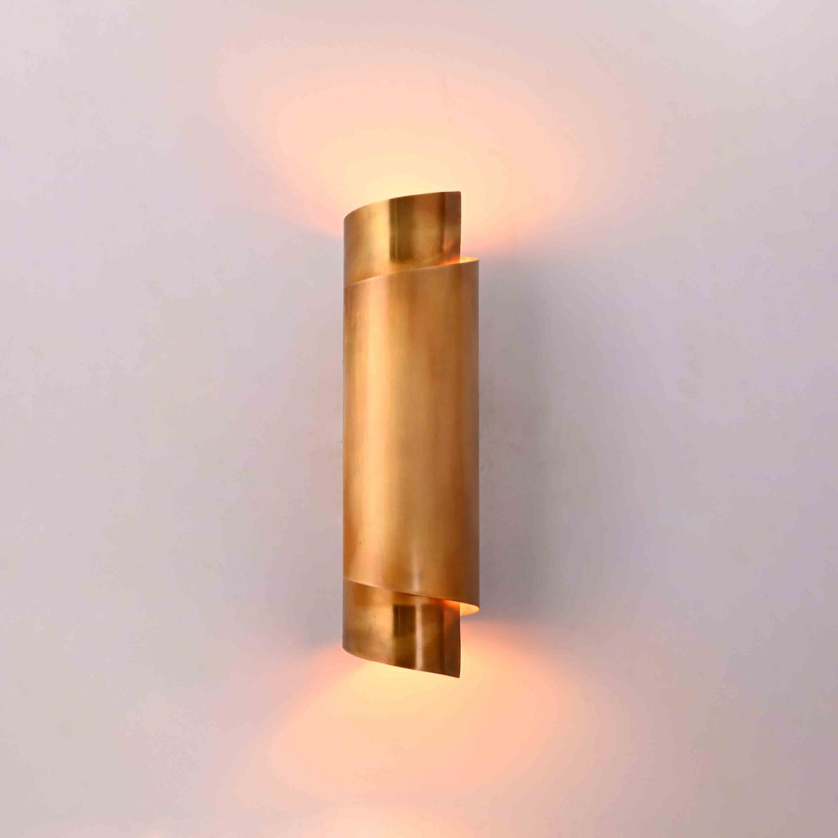 Tall brass up down wall light styled beside bookshelf and desk for warm study room lighting