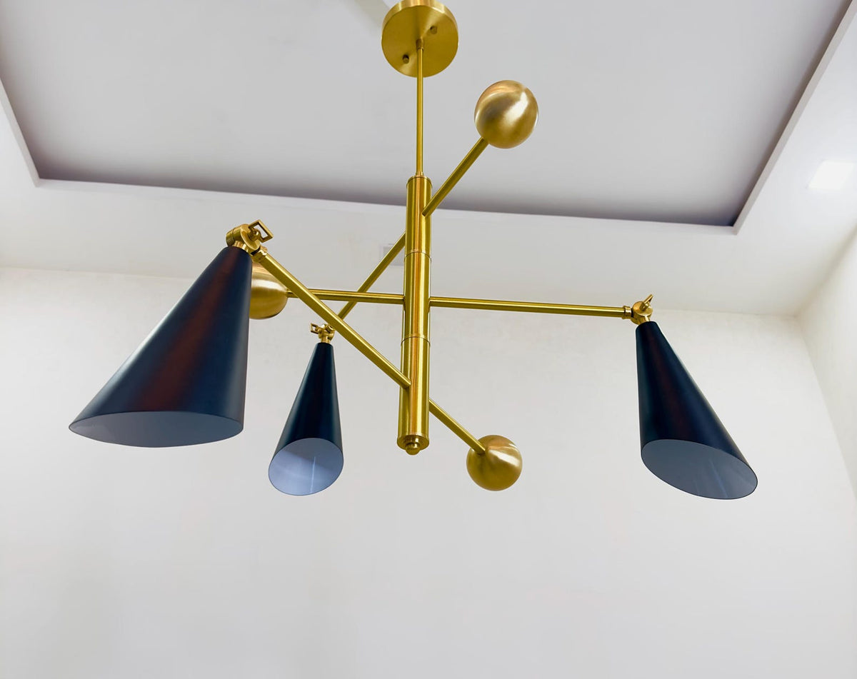 Low angle view of three cone brass chandelier highlighting solid brass arms, precision joints, and minimalist industrial design.