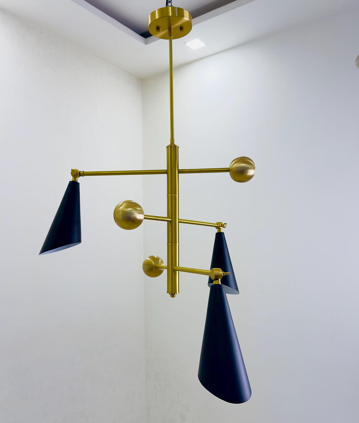Modern ceiling-mounted three cone brass chandelier designed for ambient lighting in contemporary living spaces.