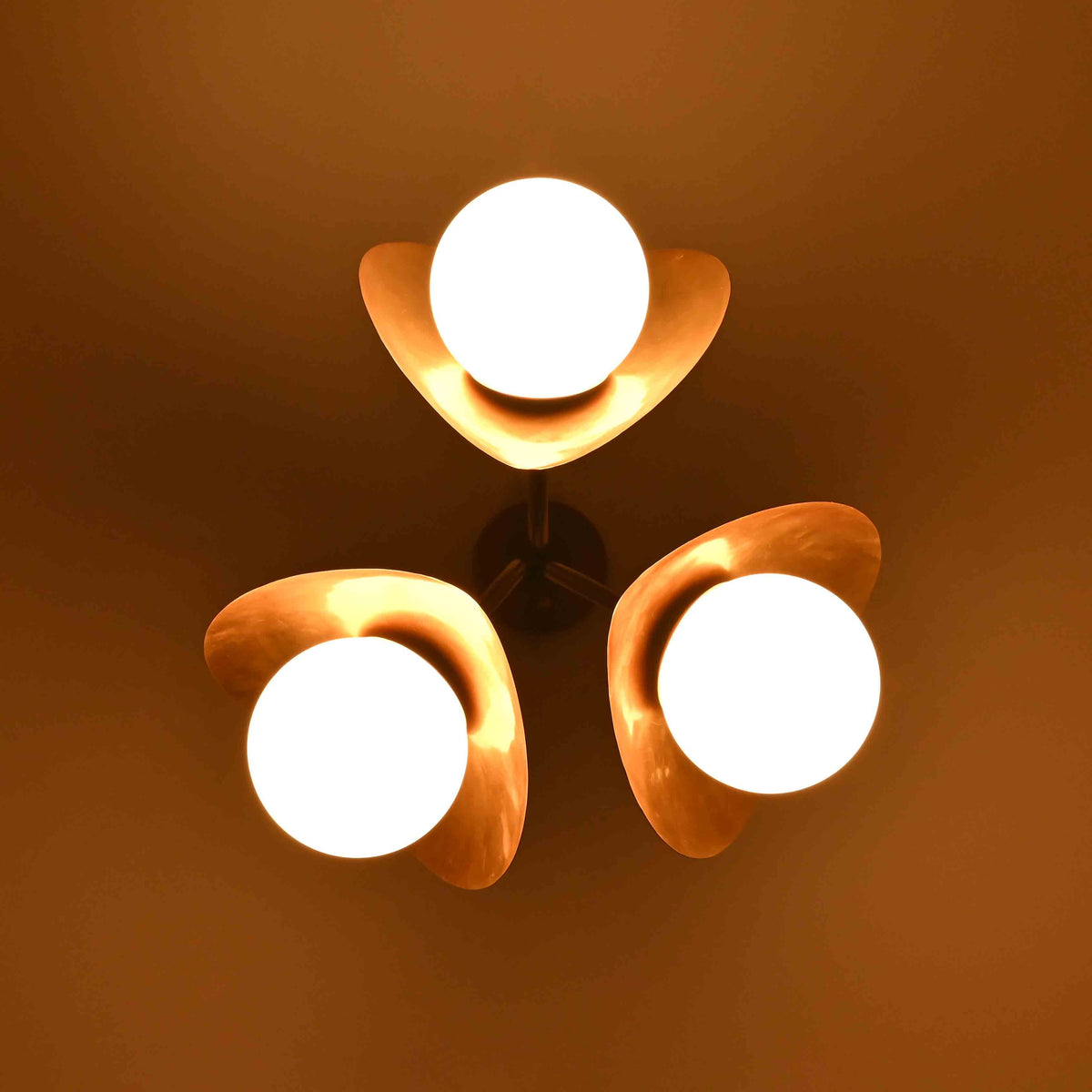 Three globe lotus ceiling fixture with brass petal details and warm opal lighting for bedroom, dining room, or living room décor