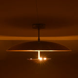 Three-light brass disc flushmount ceiling fixture glowing warmly in a dark interior