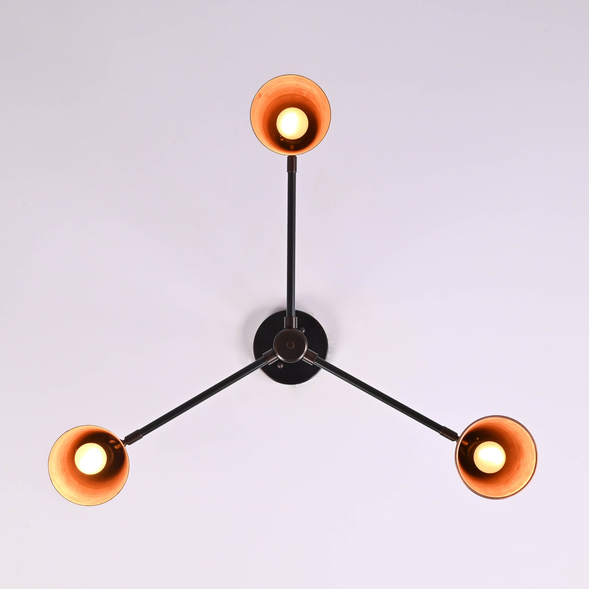 Bottom view of three light copper cone chandelier highlighting symmetrical modern design