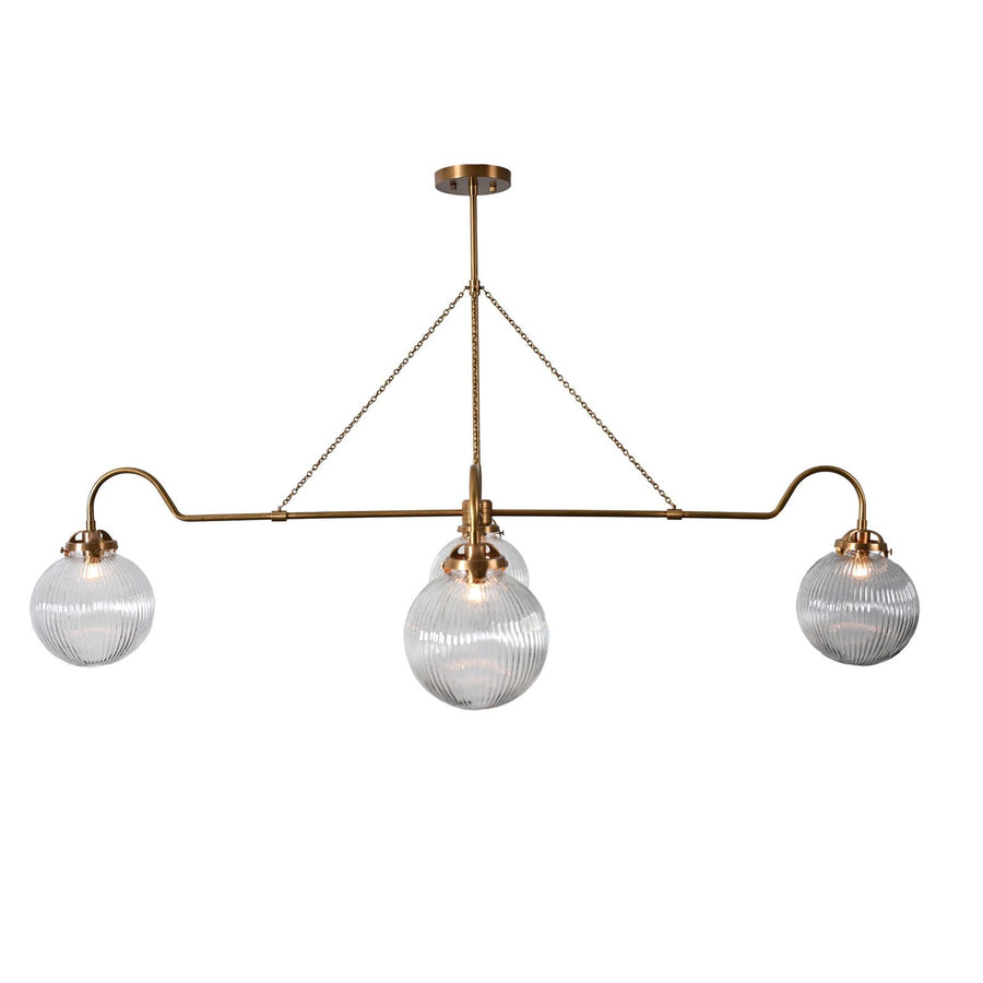 Modern linear brass chandelier with four ribbed glass globes suspended by chains, handcrafted by Brass Leaf Studio for dining or living room interiors.