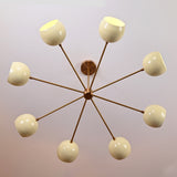 Top view of 8-arm brass chandelier showing symmetrical cream domes arranged in a circular pattern