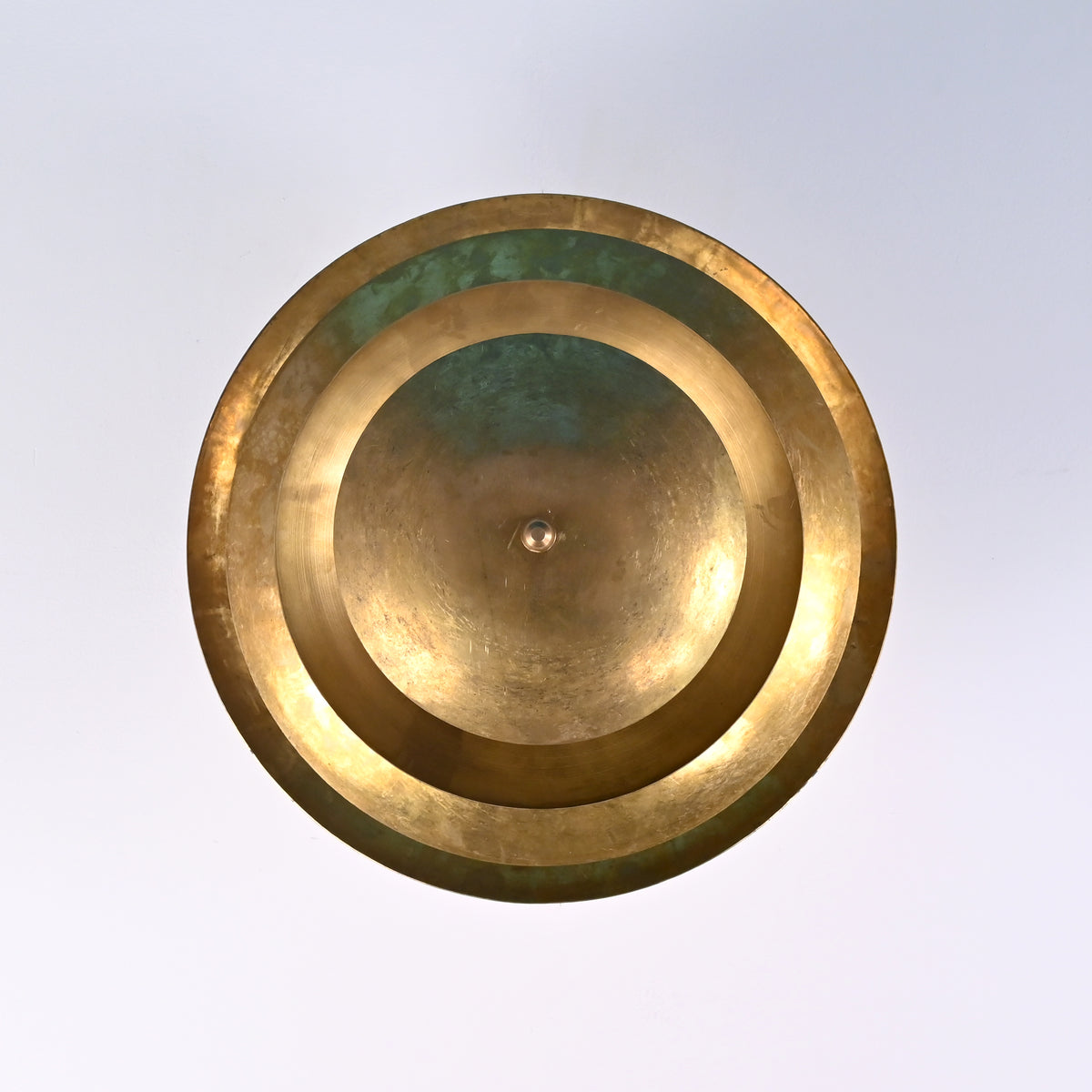 Top-down view of layered brass ceiling light showing concentric circular shades.