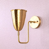 Brass wall sconce with tulip-shaped perforated shade and curved brass arm