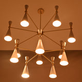Closeup of two-tier white cone chandelier with warm downward glow and elegant brushed brass connecting arms