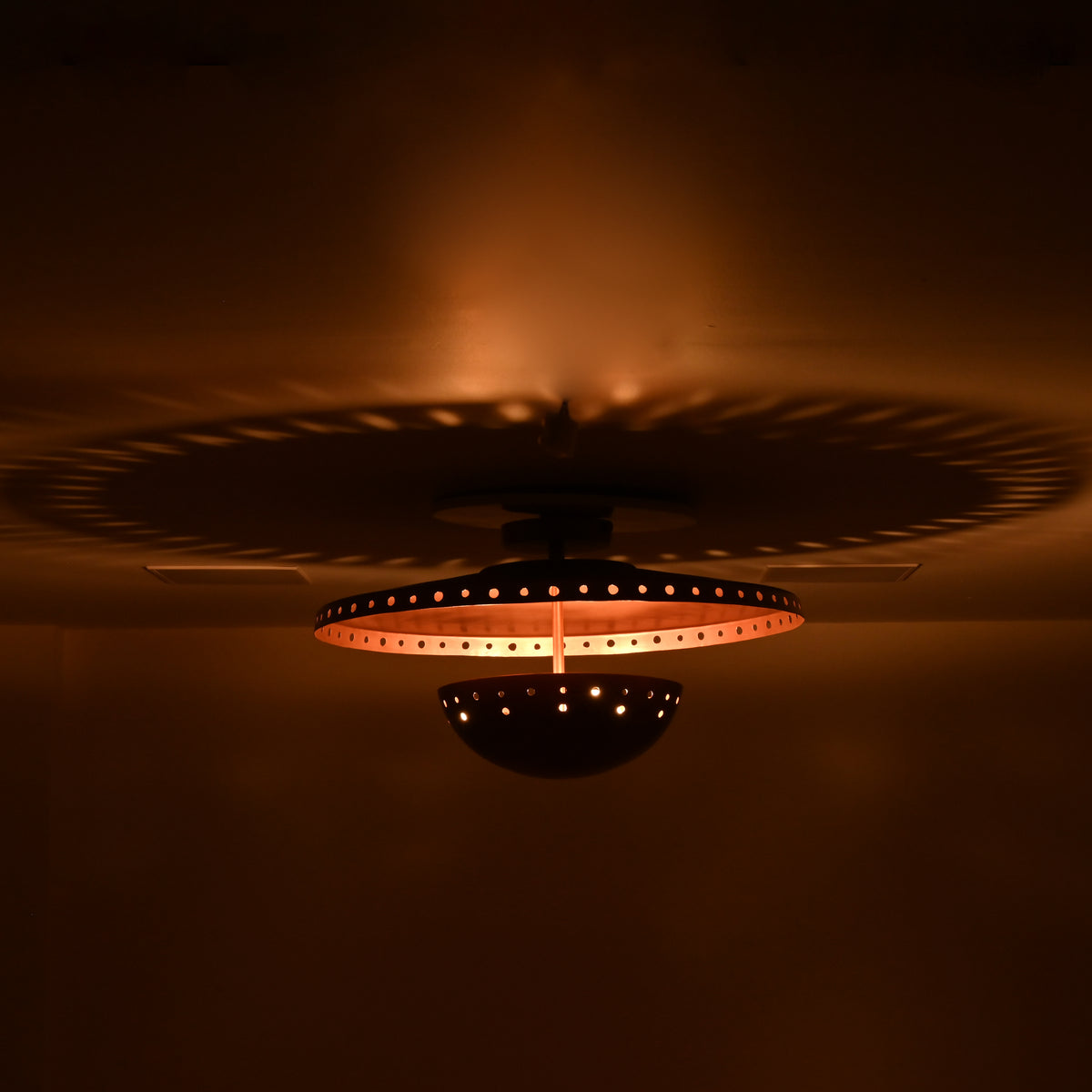 Close view of Valencia flush mount showing copper finish, perforated detailing and layered sculptural form