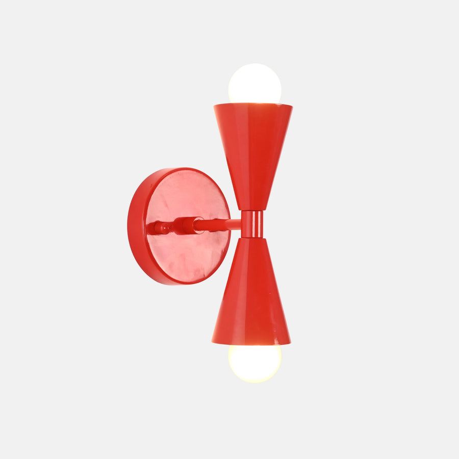 Vera Red solid brass double cone wall sconce shown illuminated with warm upward and downward glow
