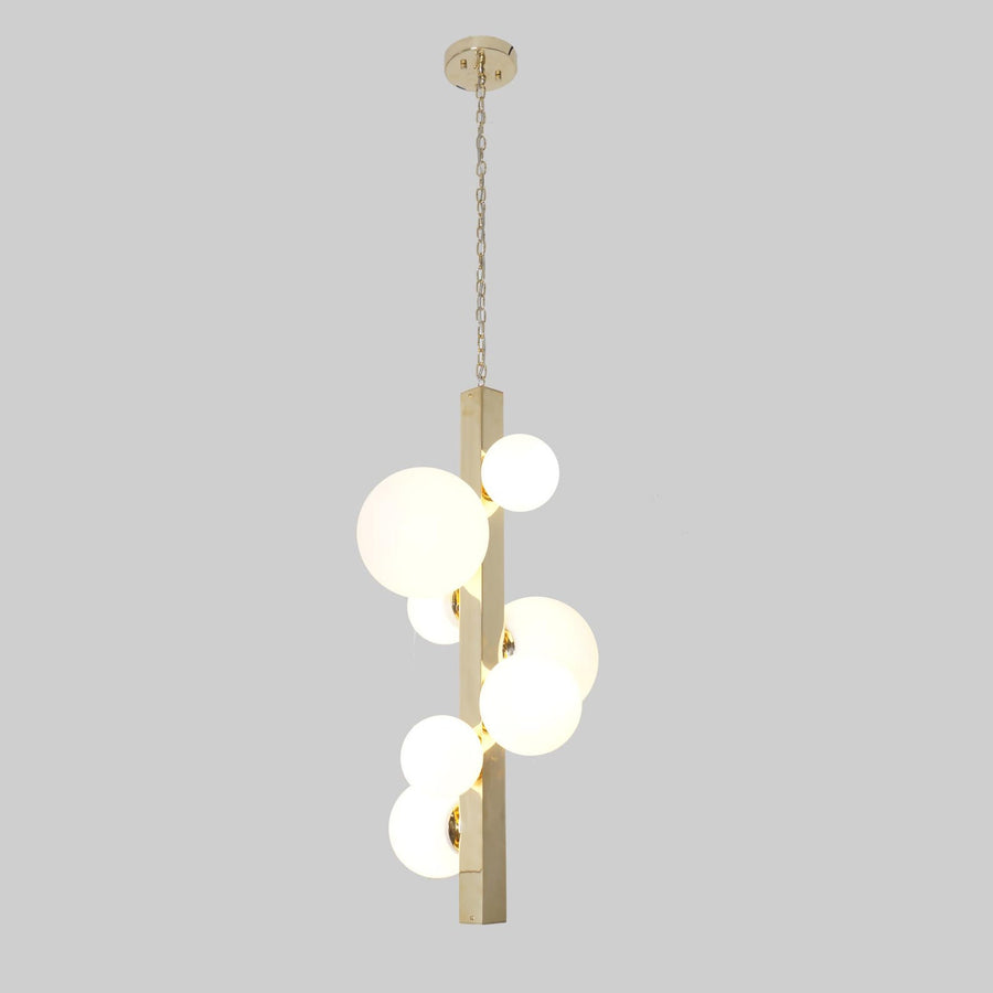 Vertical brass chandelier with frosted glass globes suspended on chain, handmade by Brass Leaf Studio.