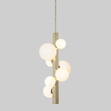 Side view of modern linear brass chandelier featuring spherical frosted globes in vertical arrangement.