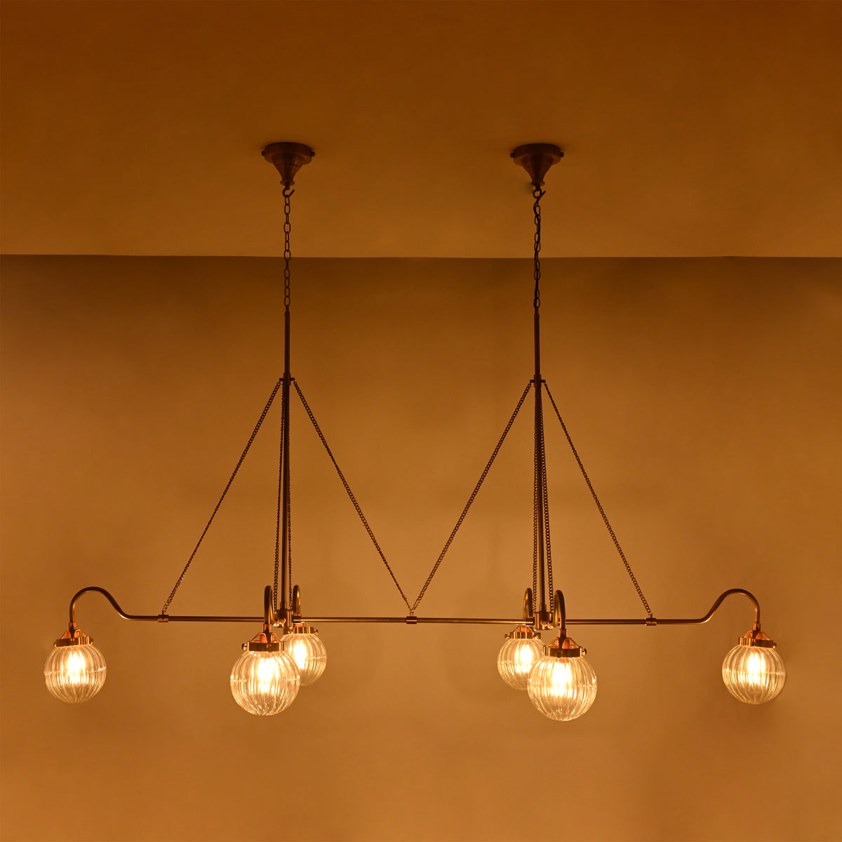 Warm ambient glass globe chandelier with ribbed shades, ideal for dining rooms, living rooms, and hospitality interiors