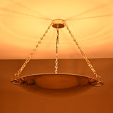 Brass chain chandelier emitting soft warm lighting with wide reflector bowl design