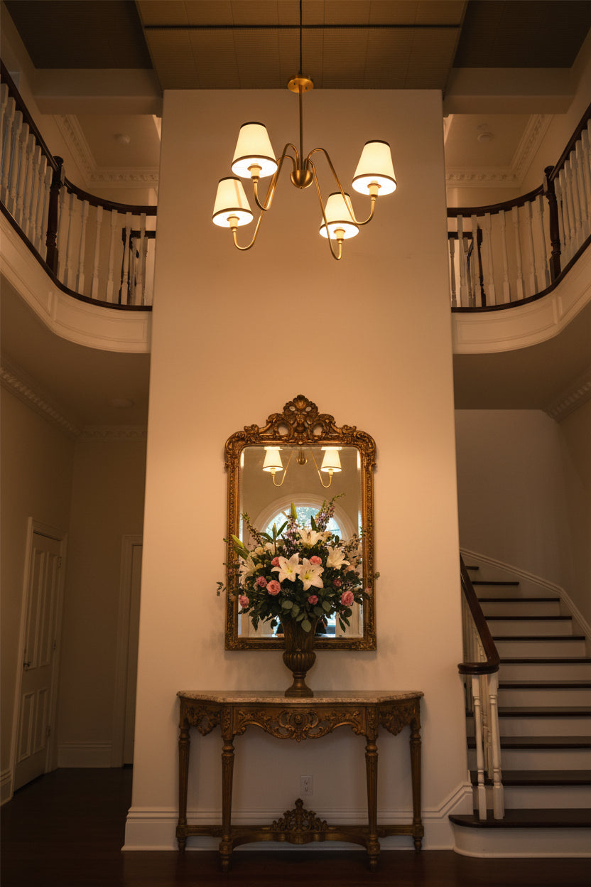 Warm glowing brass chandelier with four fabric shades creating soft ambient light for elegant interiors