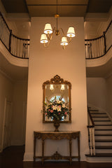 Warm glowing brass chandelier with four fabric shades creating soft ambient light for elegant interiors