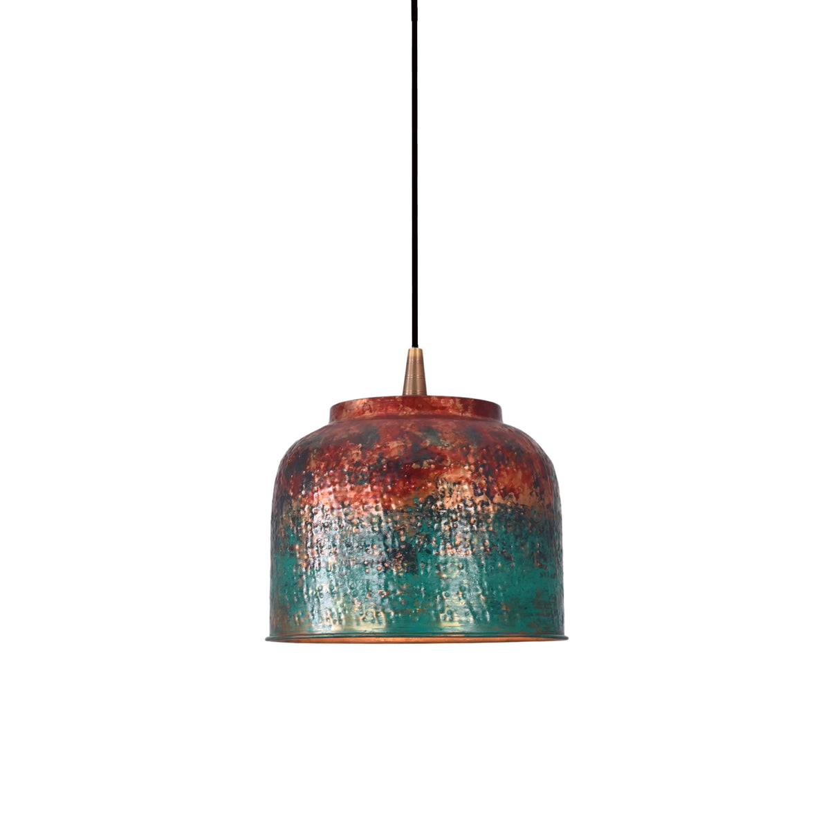 Copper drum pendant light switched on, creating a warm downward glow from the textured inner shade