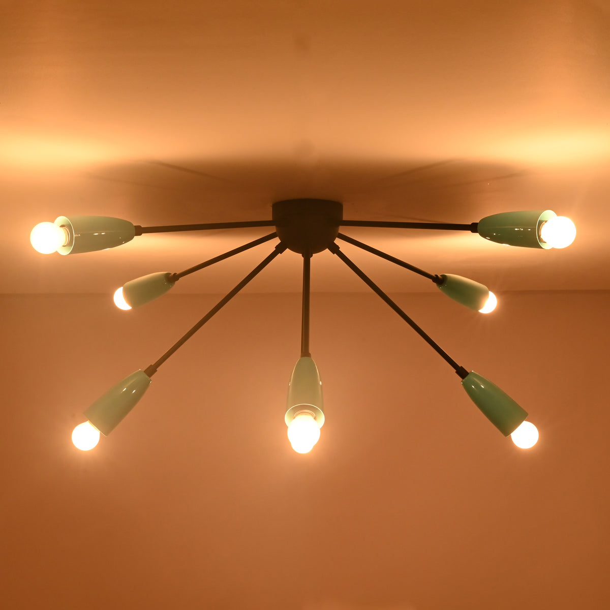 Warm modern orbit flush mount chandelier enhancing ambient atmosphere in interior spaces