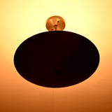 5-light blackened brass ceiling fixture glowing with warm indirect uplighting