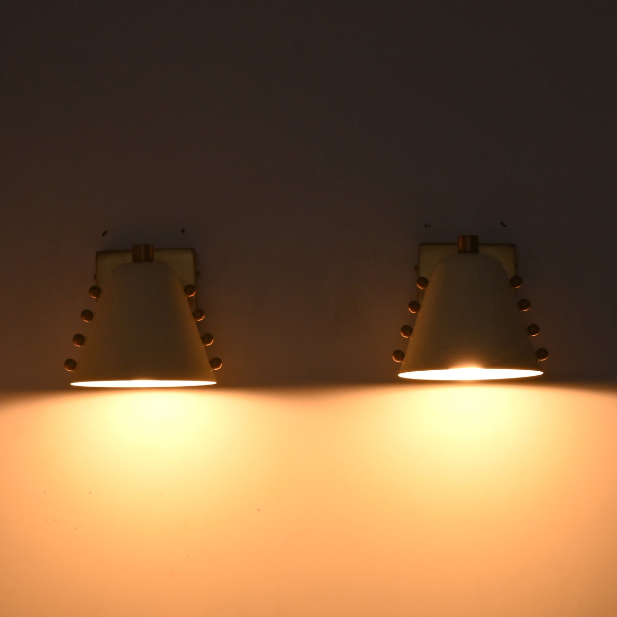 White and brass vanity wall lights with soft downward glow for bathroom mirrors and powder room styling