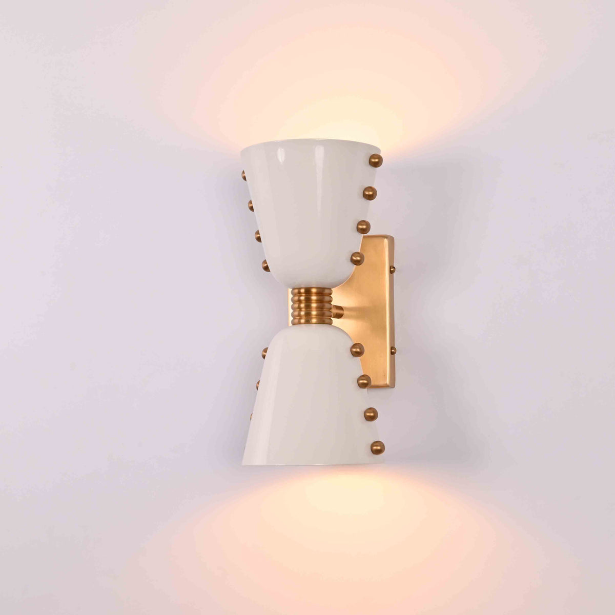 White and brass up down wall fixture with sculptural cone shades for stylish accent lighting