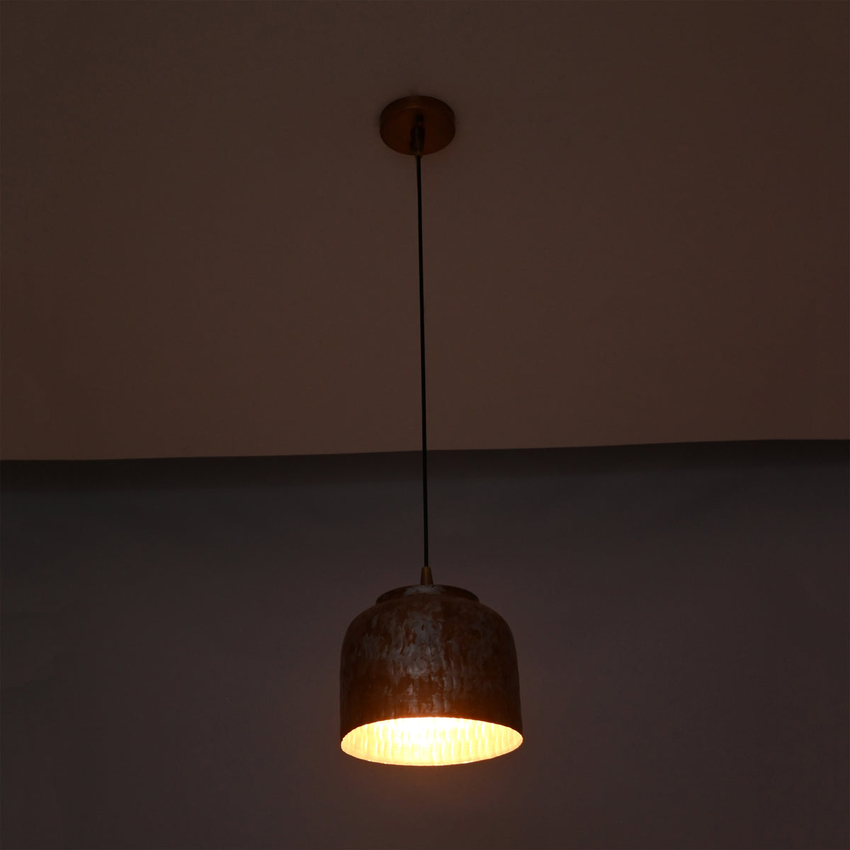 Whitewashed copper pendant light shown from front with compact rounded drum shade and warm interior glow